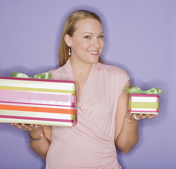 Woman holding big and small gifts.