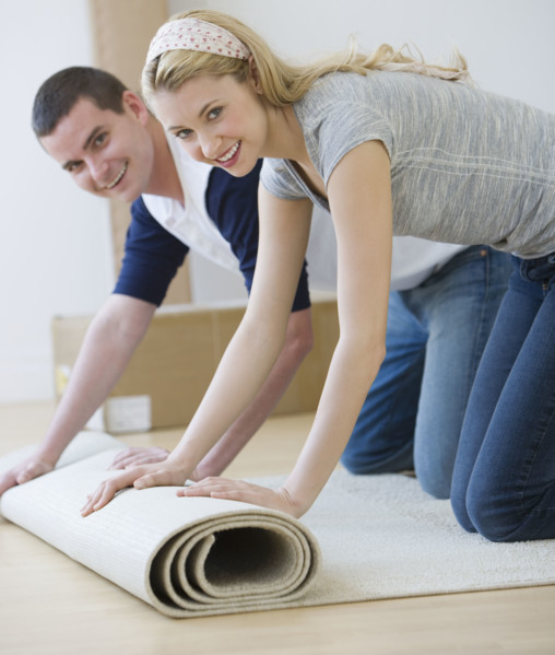 Couple unrolling rug.