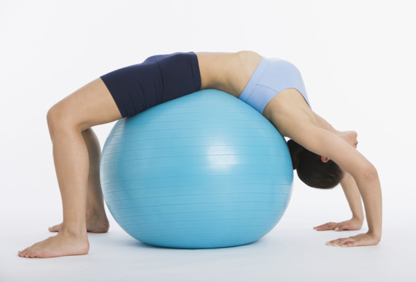 Woman stretching on exercise ball.