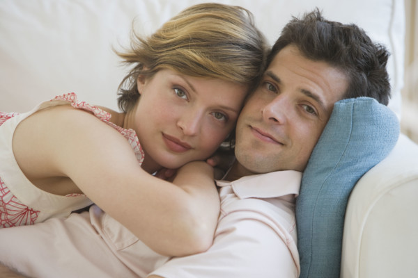 Couple hugging on sofa.