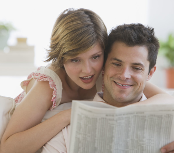 Couple reading newspaper.