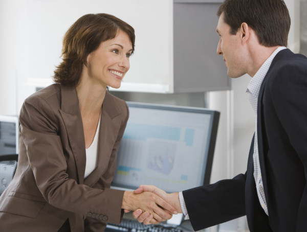 Businesswoman and businessman shaking hands.