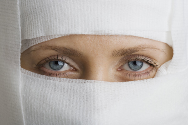 Woman’s face wrapped in bandages.