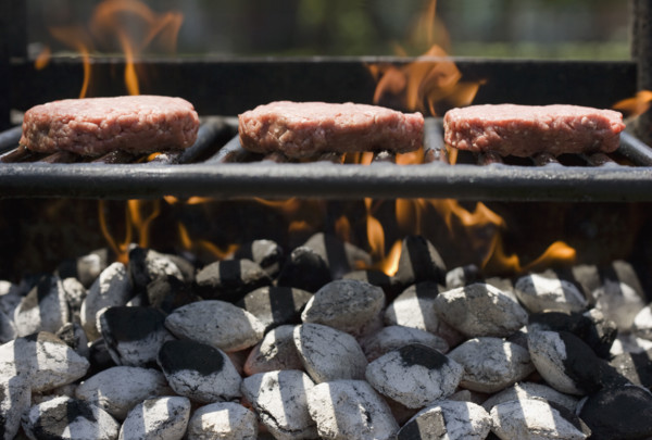 Hamburgers cooking on grill.