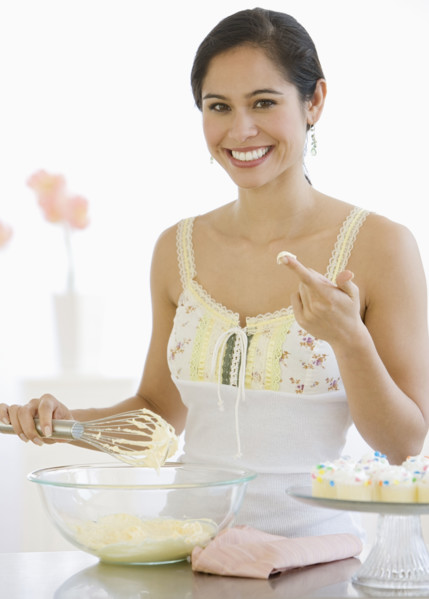 Woman stirring batter in kitchen.