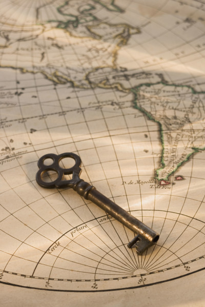 Old fashioned key on globe map.