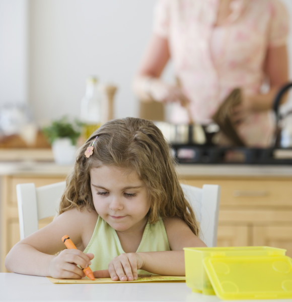 Girl coloring at kitchen table.