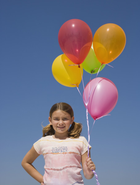 Girl holding balloons.