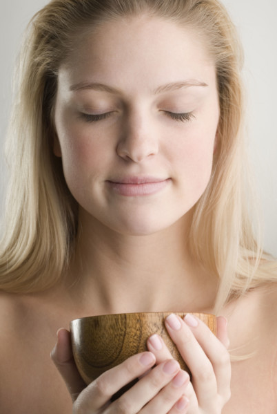 Woman meditating and holding wooden cup. Date : 2006