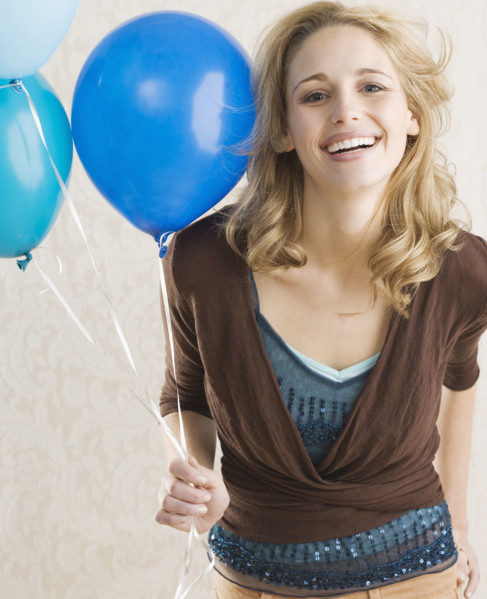Woman holding balloons and smiling. Date : 2006