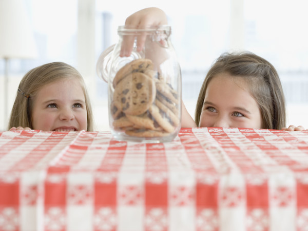 Sisters taking cookies from jar. Date : 2006