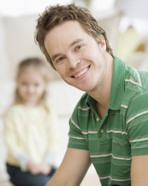 Father smiling with daughter in background. Date : 2007