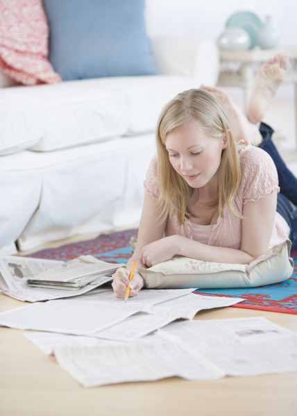 Woman reading newspaper classifieds. Date : 2007