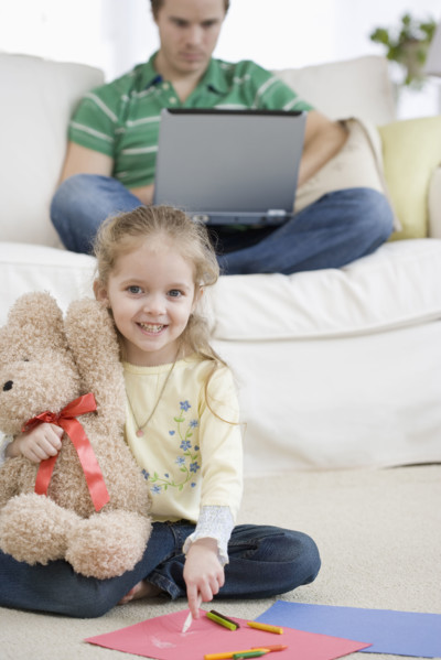 Father and daughter relaxing in livingroom. Date : 2007