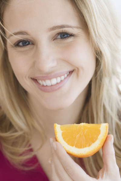 Close up of woman holding orange wedge. Date : 2007