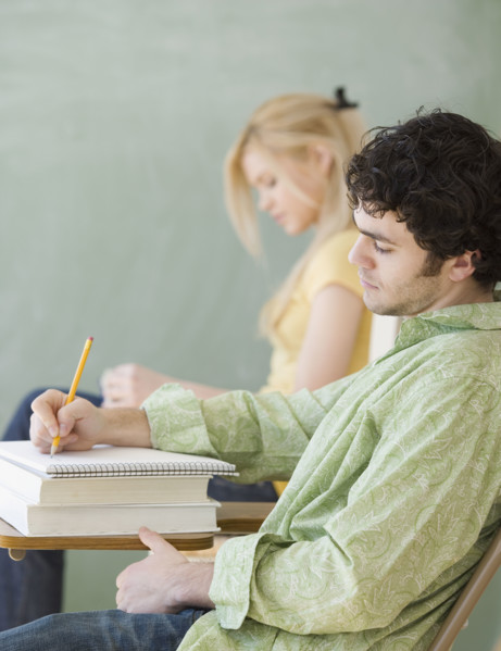 Man writing at desk in classroom. Date : 2007