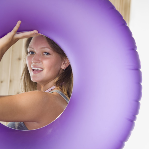 Young woman smiling through middle of inner tube. Date : 2006