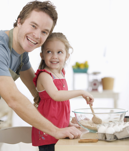 Father and daughter mixing batter in kitchen. Date : 2007