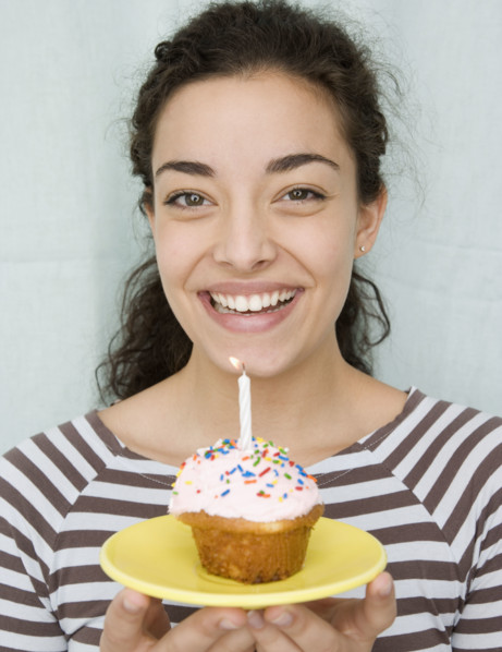 Woman holding cupcake with candle. Date : 2007