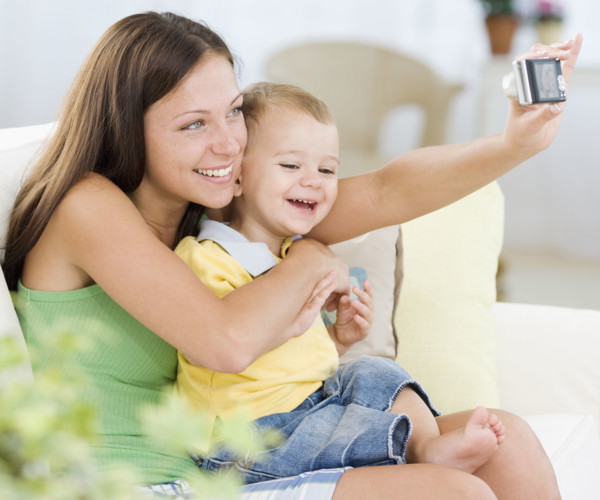 Mother taking own photograph with baby. Date : 2007