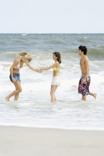 Friends standing in ocean surf. Date : 2007