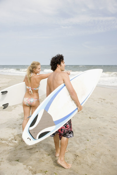 Couple holding surfboards at beach. Date : 2007