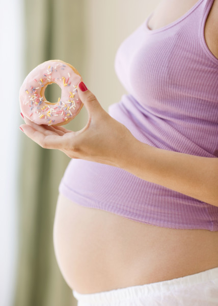 Pregnant woman holding donut. Date : 2007