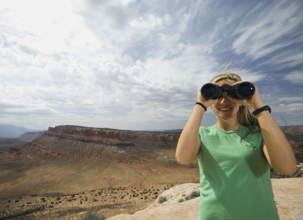 Woman looking through binoculars. Date : 2007