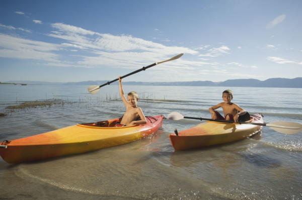 Brothers paddling in canoes on lake, Utah, United States. Date : 2007