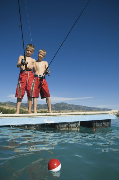 Brothers fishing off dock in lake, Utah, United States. Date : 2007