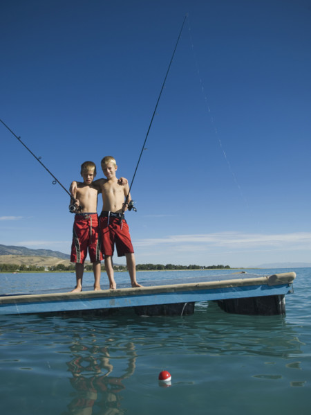 Brothers fishing off dock in lake, Utah, United States. Date : 2007