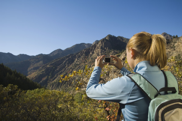 Woman taking photograph of valley, Utah, United States. Date : 2007