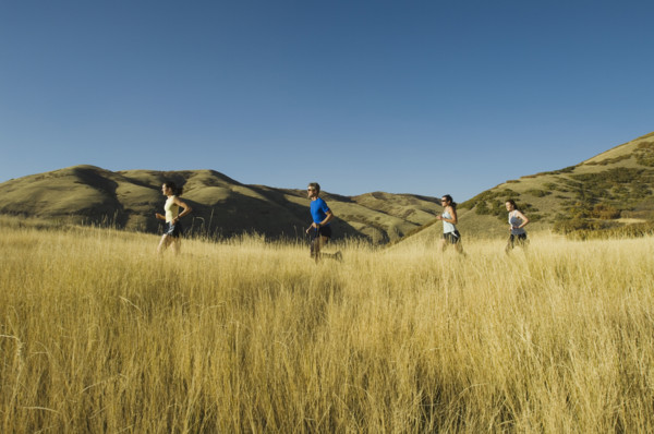 Group of people running in field, Utah, United States. Date : 2007
