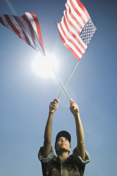 Female army soldier holding American flags. Date : 2007