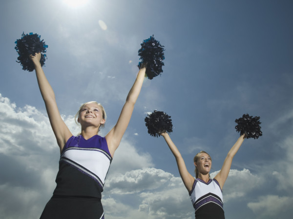 Two cheerleaders holding pom poms over head. Date : 2007
