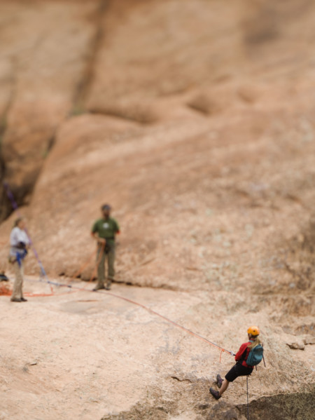 Woman in rappelling gear at top of cliff. Date : 2007