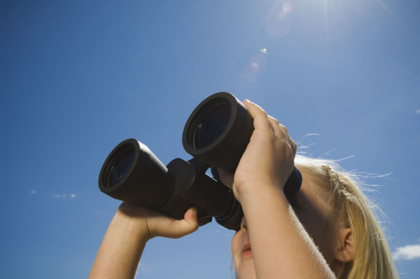 Girl looking through binoculars, Utah, United States. Date : 2007