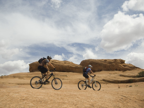 Couple riding mountain bikes in desert. Date : 2007