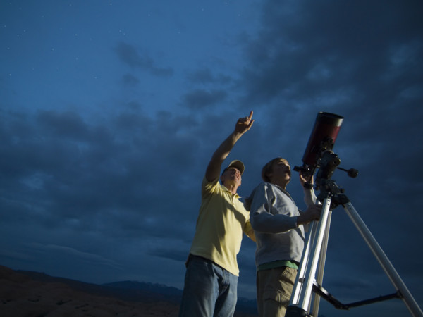 Couple using telescope on tripod. Date : 2007