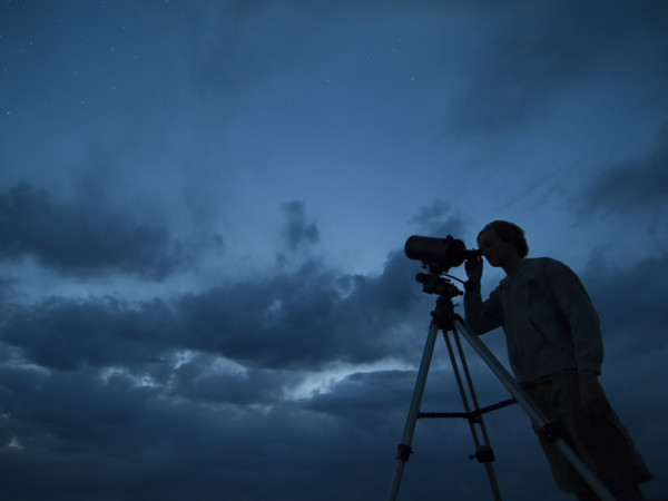 Man using telescope on tripod. Date : 2007