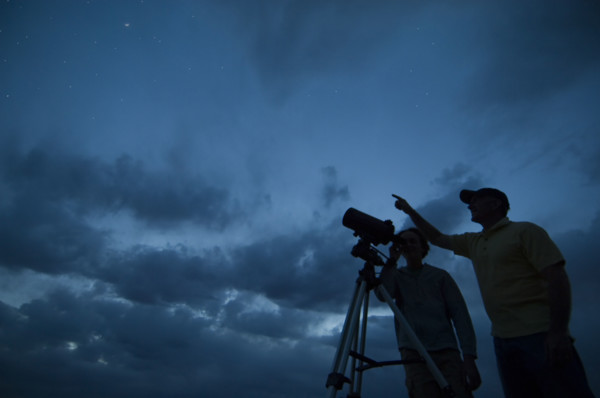 Couple using telescope on tripod. Date : 2007