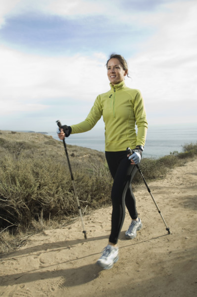 Hispanic woman pole walking along coast in California, United States. Date : 2007