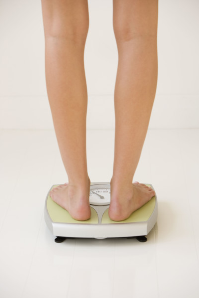 Woman standing on scale.