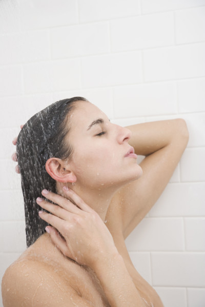 Woman standing under shower.