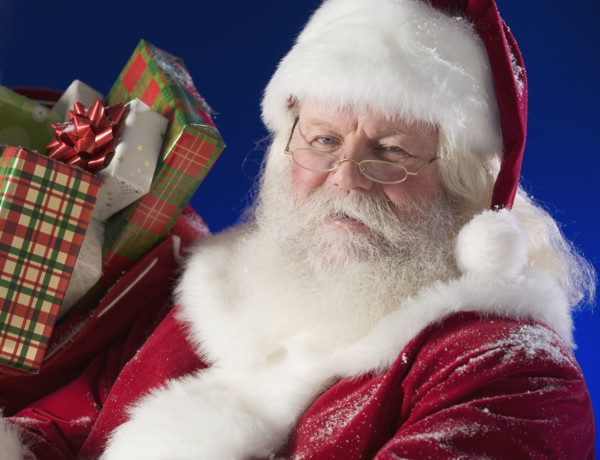 Santa Claus next to bag of toys.