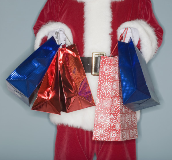 Santa Claus holding shopping bags.