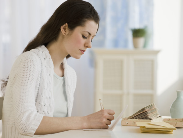 Woman writing at table.