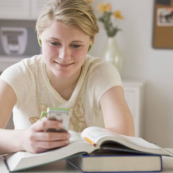 Teenaged girl looking at mp3 player.