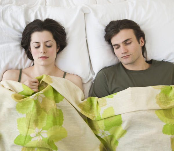 Couple sleeping in bed.