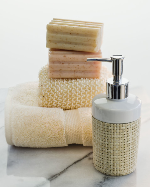 Stack of soap and towels next to lotion.